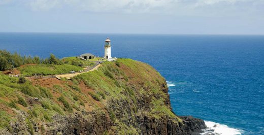 white lighthouse beside a cliff