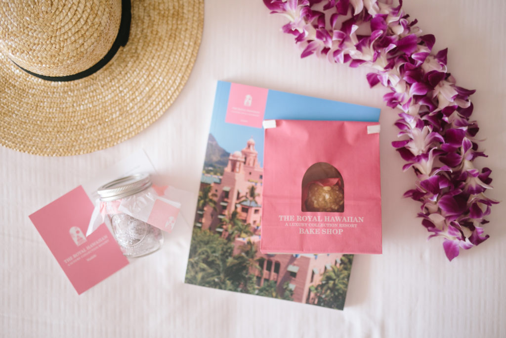flat-lay photography of The Royal Hawaiian poster beside moth orchid