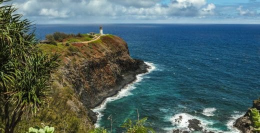 lighthouse on cliff near body of water