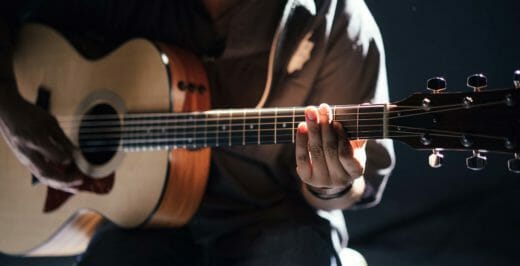 man holding acoustic guitar